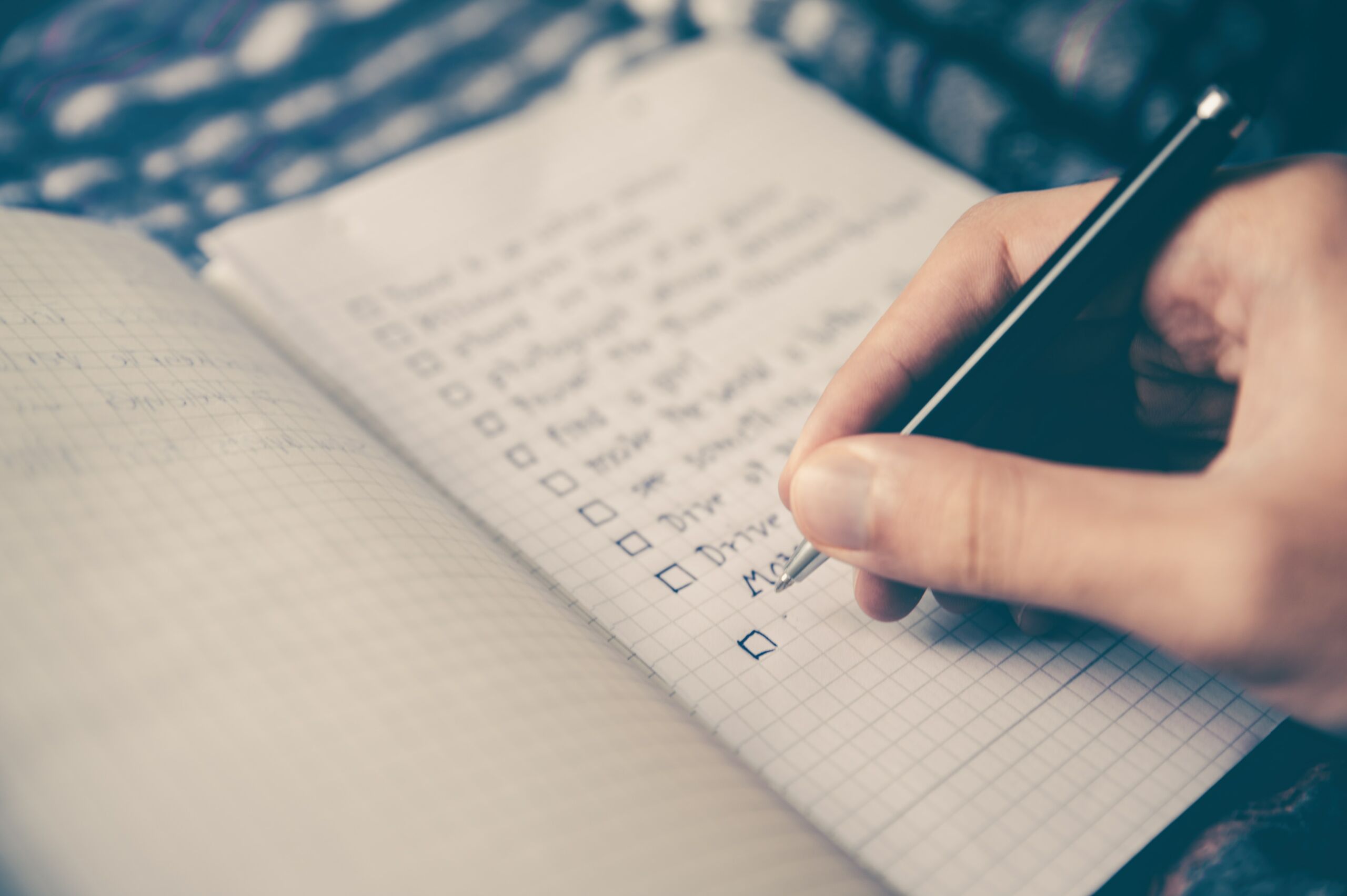 person writing a checklist on paper