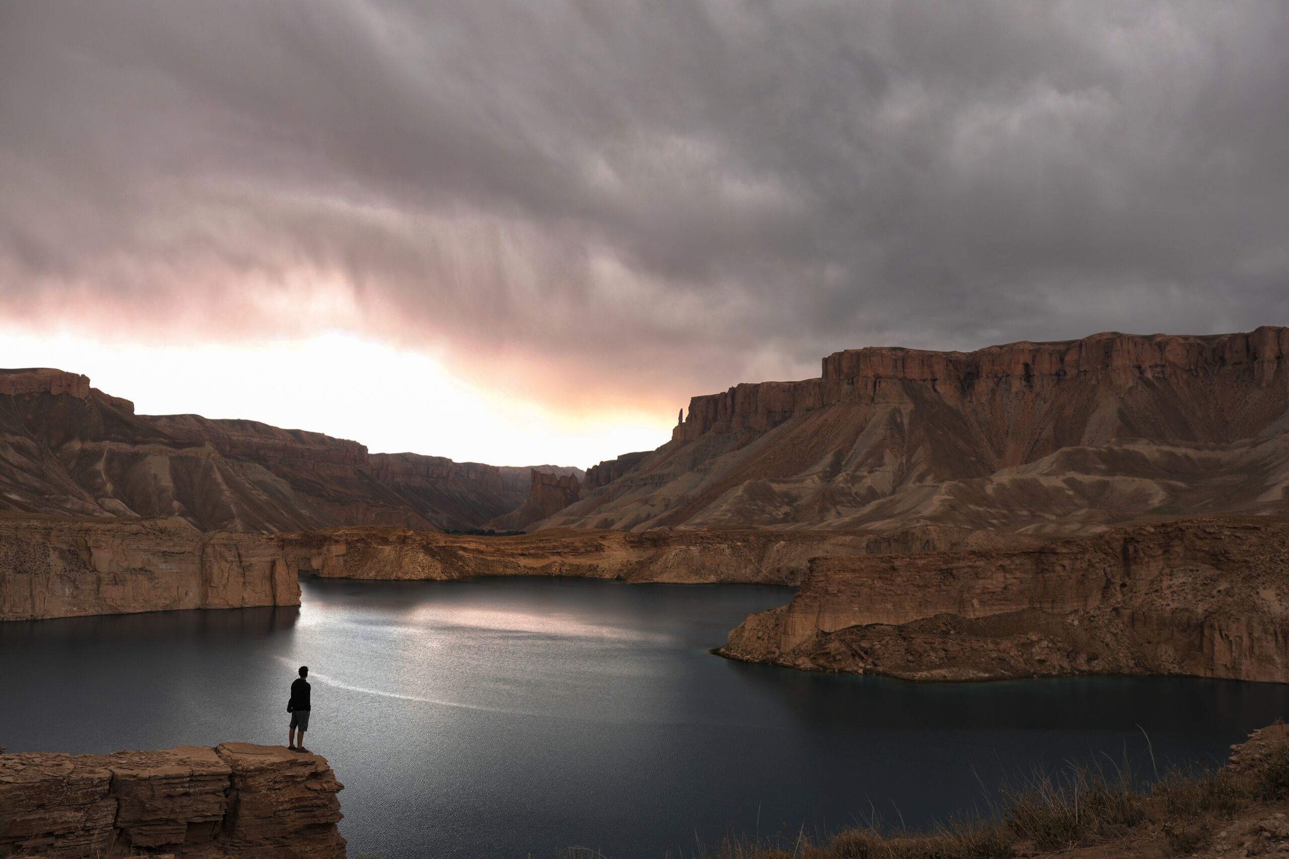 person standing on a plateau overlooking a lake