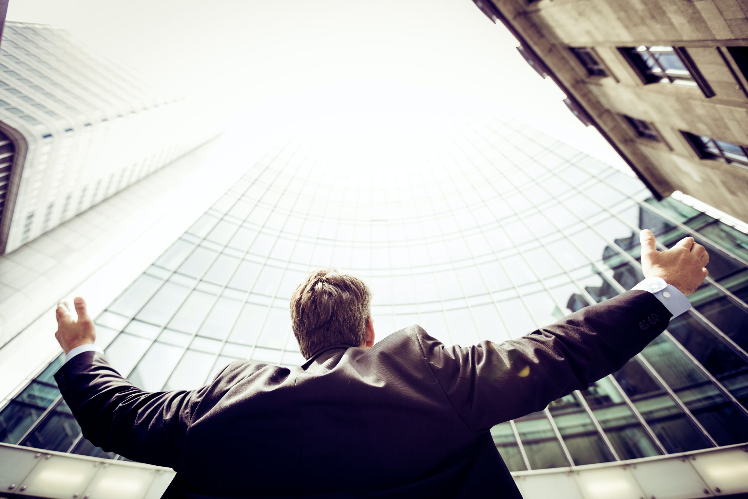 man looking at a skyscraper while cheering