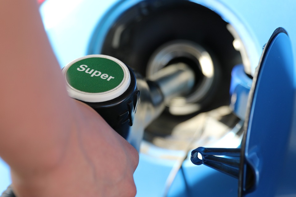 Gas is being pumped into a car with it saying "super" on it