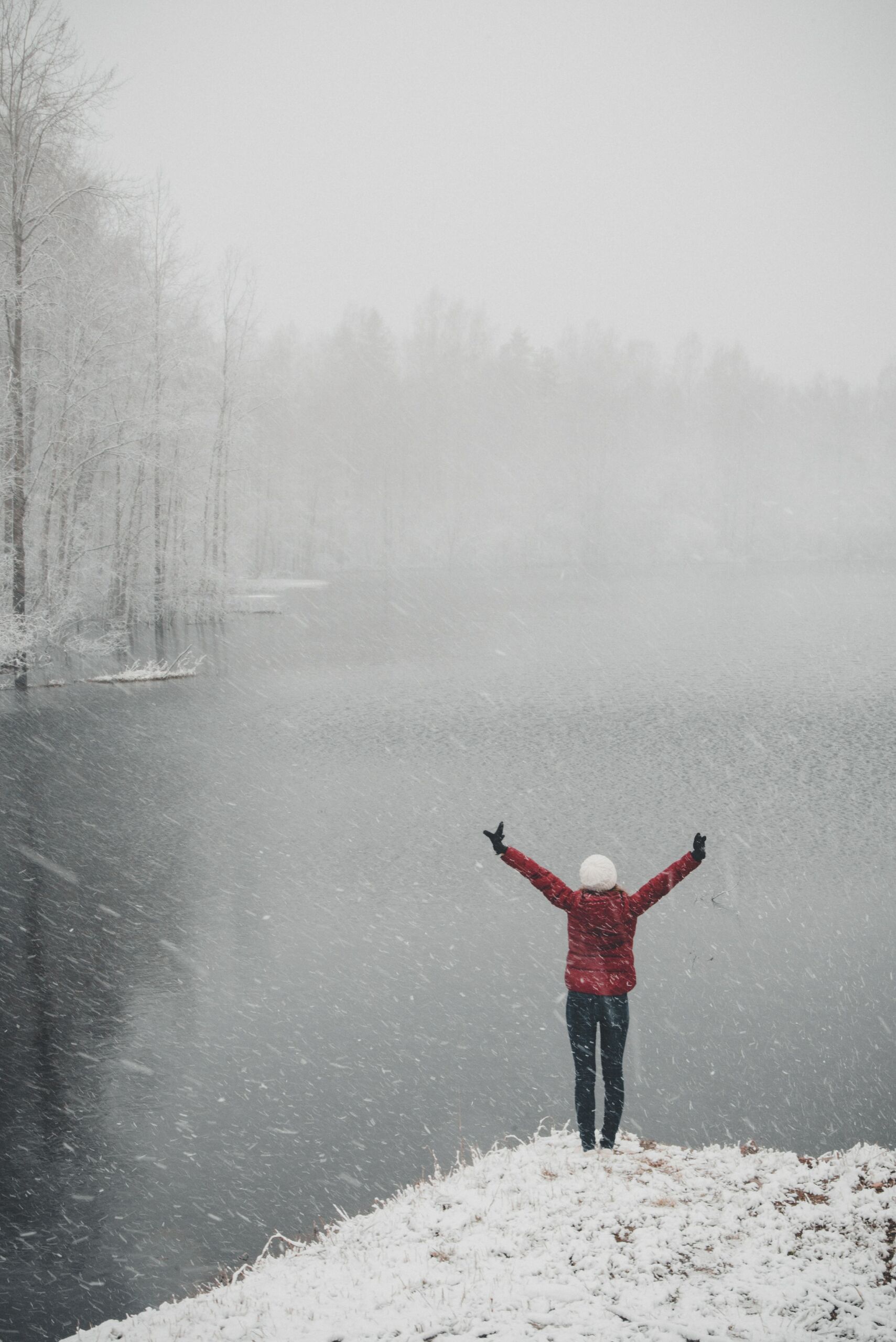 Woman overlooking a snowy lake feeling accomplished