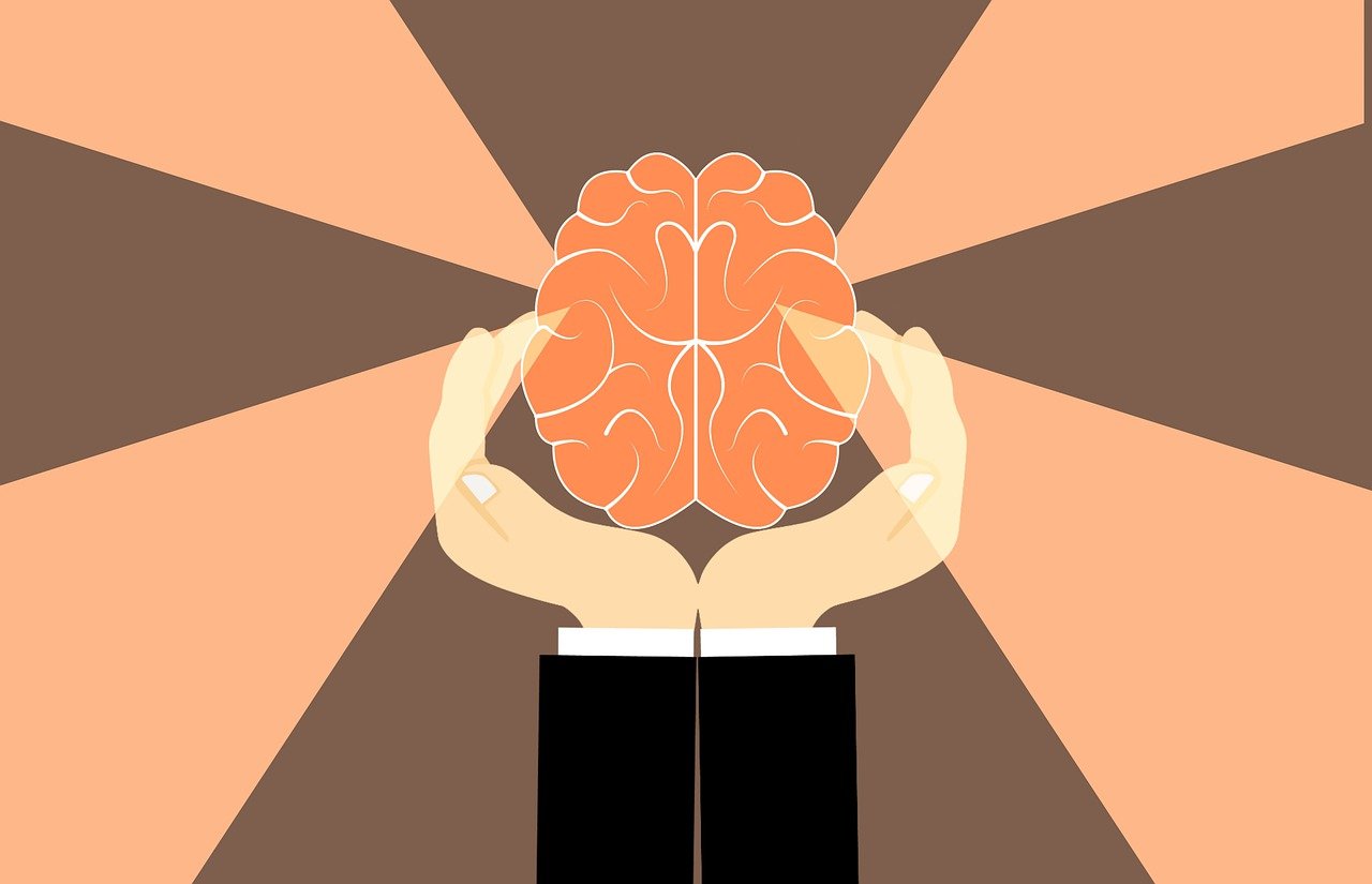 hands holding a brain with lights coming off it