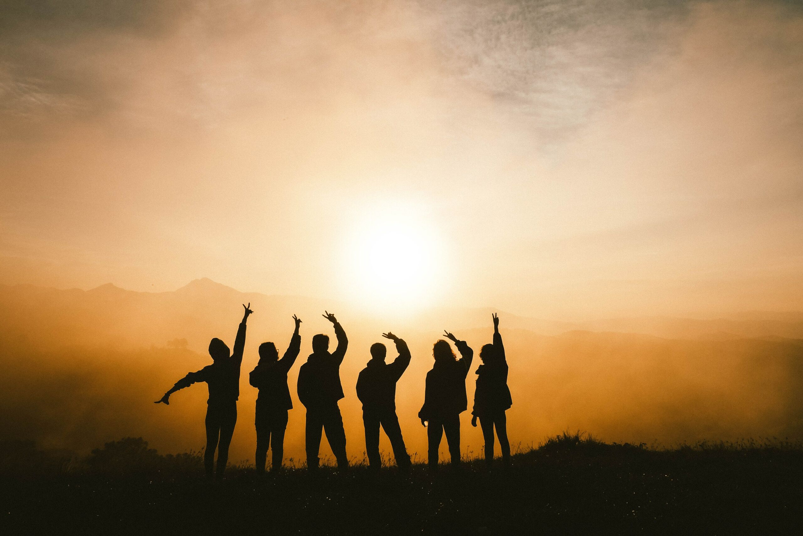 Silhouette of 6 people n top of a mountain