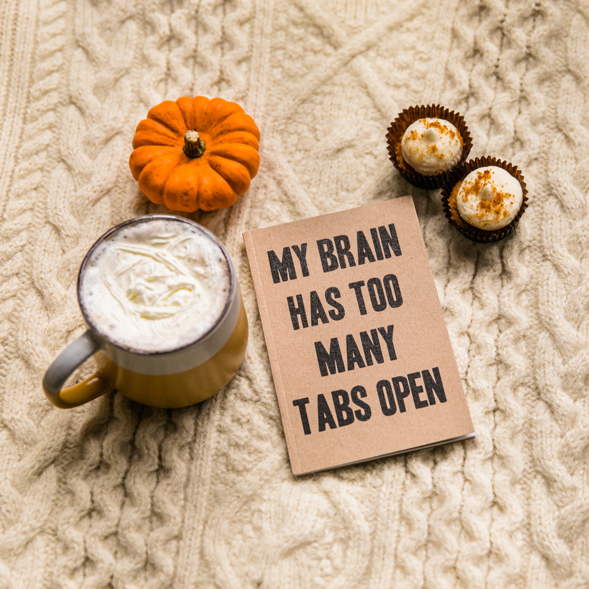 Coffee and two muffins with a sign that says "my brain has too many tabs open"